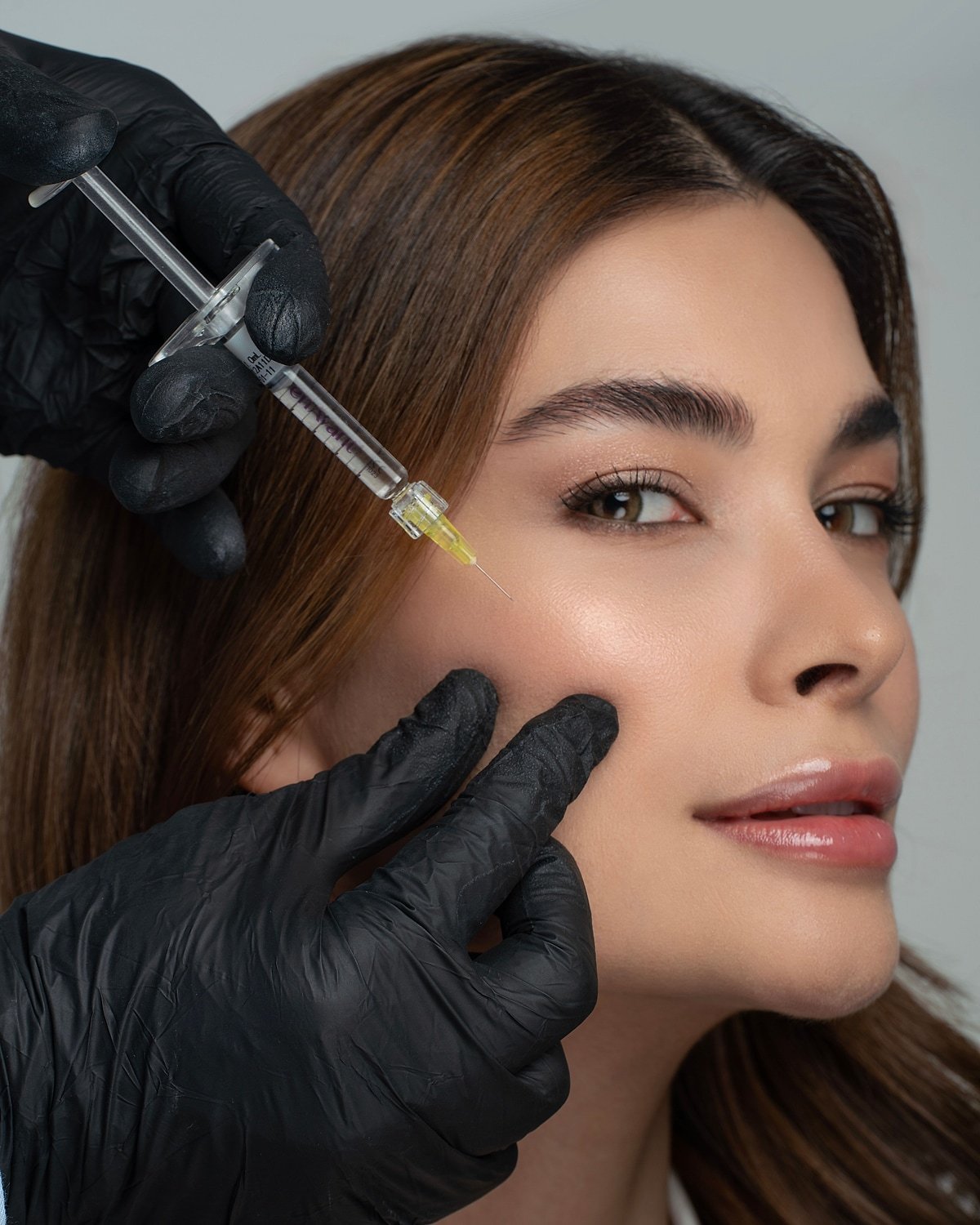 Close-up of an adult woman’s face during preparation for an injectable treatment